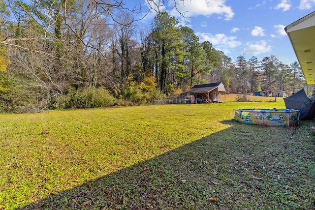 view of yard with a storage shed and a covered pool