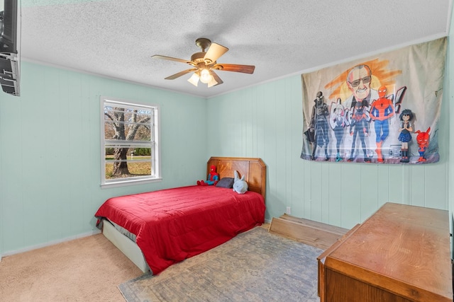 carpeted bedroom featuring ceiling fan, ornamental molding, and a textured ceiling