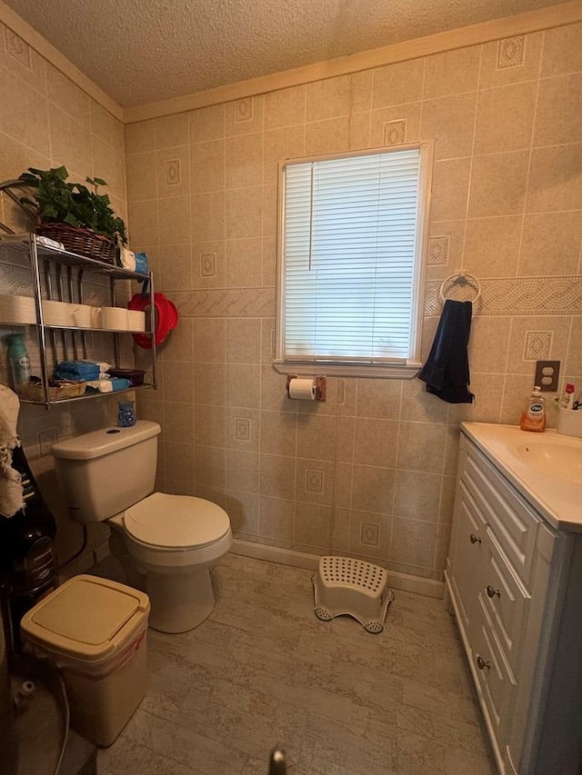 116 Butterfield Dr, Dalton, GA 30721 - half bathroom with tile walls, toilet, vanity, a textured ceiling, and wood finished floors