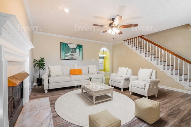 living room with hardwood / wood-style flooring, ceiling fan, ornamental molding, and plenty of natural light