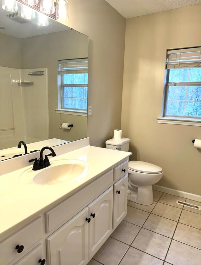 unfurnished bedroom with hardwood / wood-style flooring, ceiling fan, a textured ceiling, and ensuite bath