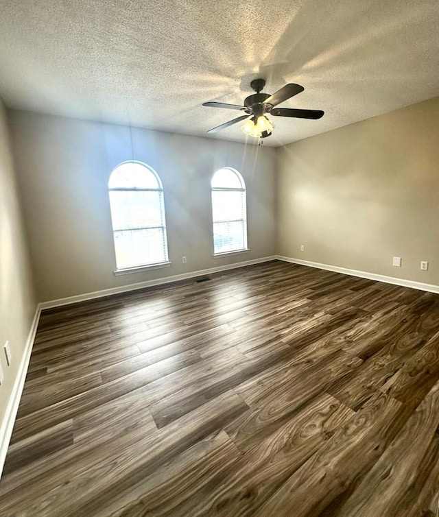 spare room featuring ceiling fan, dark hardwood / wood-style flooring, and a textured ceiling