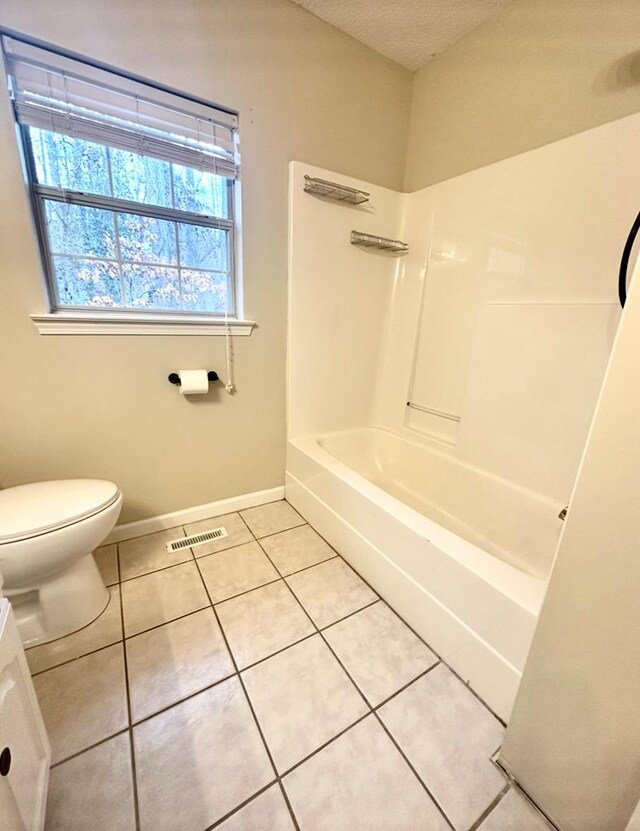 bedroom with ceiling fan, ensuite bathroom, a textured ceiling, and light hardwood / wood-style flooring