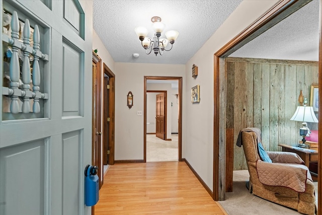 3932 Tibbs Bridge Rd, Dalton, GA 30721 - hall featuring wood walls, a chandelier, light wood-style flooring, and a textured ceiling