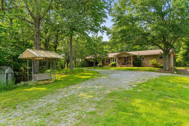 3932 Tibbs Bridge Rd, Dalton, GA 30721 - view of grassy yard with a porch and a storage unit