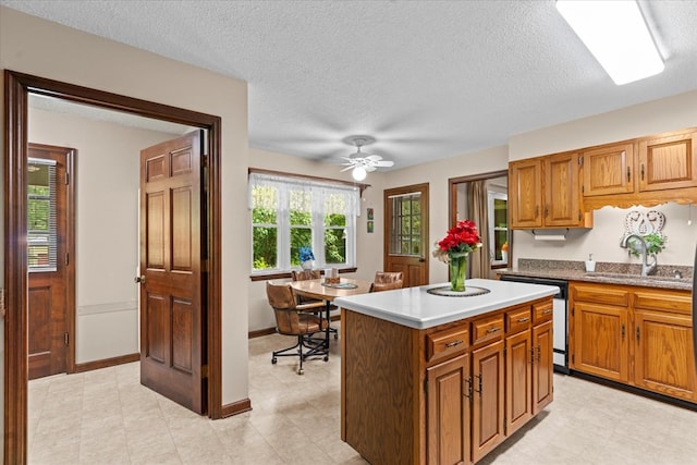3932 Tibbs Bridge Rd, Dalton, GA 30721 - kitchen featuring white dishwasher, a center island, brown cabinets, a textured ceiling, and a ceiling fan
