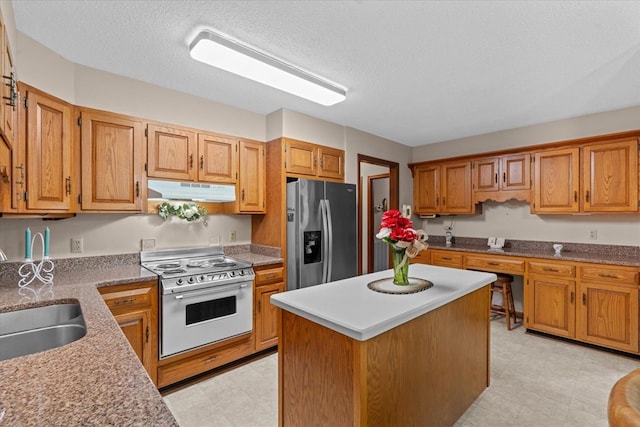 3932 Tibbs Bridge Rd, Dalton, GA 30721 - kitchen with stainless steel fridge, white electric range oven, under cabinet range hood, a kitchen island, and a textured ceiling