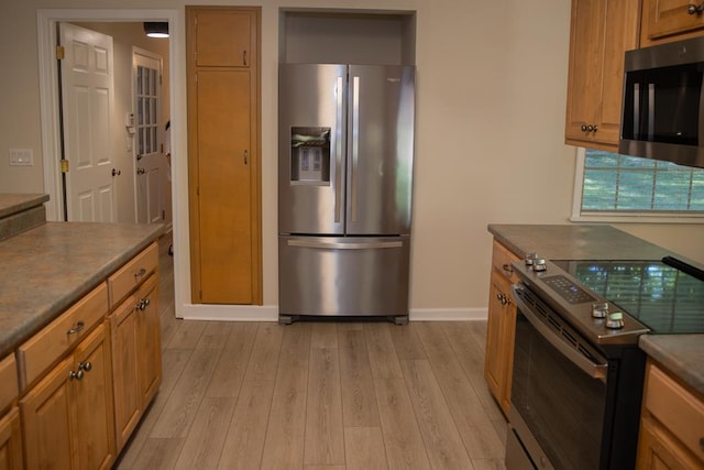 kitchen with light wood-type flooring and appliances with stainless steel finishes