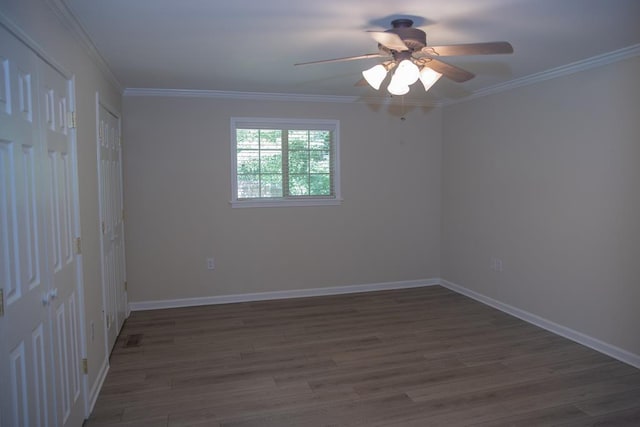 spare room with crown molding, dark hardwood / wood-style floors, and ceiling fan