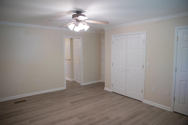 unfurnished bedroom with ceiling fan, ornamental molding, light hardwood / wood-style floors, and a closet