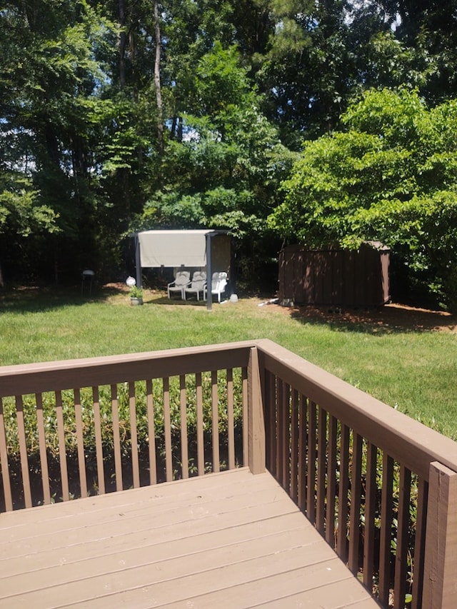 wooden deck featuring a lawn