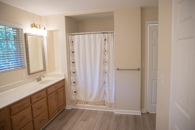 bathroom with hardwood / wood-style flooring, vanity, and walk in shower