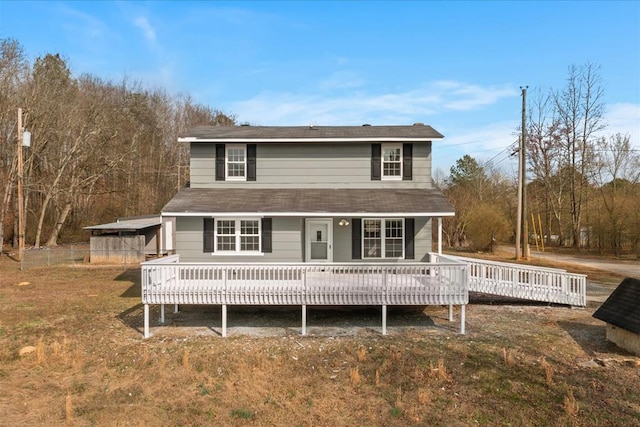 back of property featuring a wooden deck and a yard