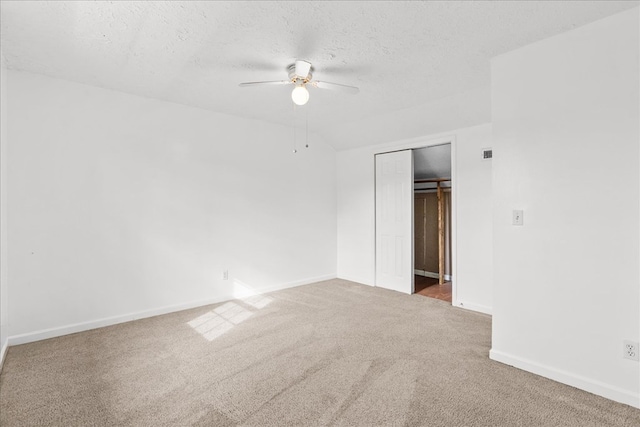 spare room featuring baseboards, a textured ceiling, ceiling fan, and carpet flooring