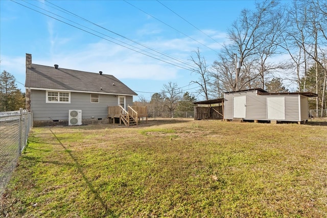 view of yard with an outbuilding, ac unit, a storage unit, and fence