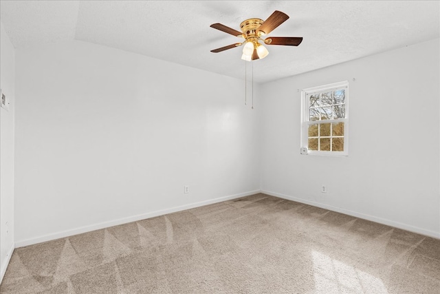 carpeted empty room featuring baseboards, a textured ceiling, and ceiling fan