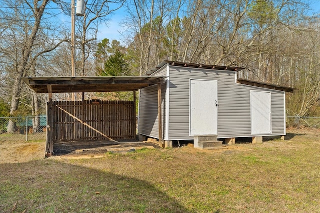 view of shed with a carport and fence