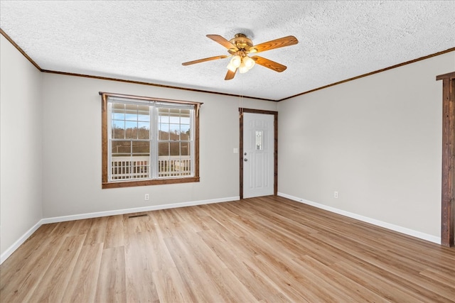 spare room with light wood-type flooring, a textured ceiling, ornamental molding, and a ceiling fan