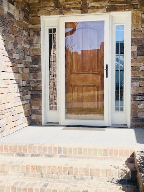 entrance to property featuring brick siding