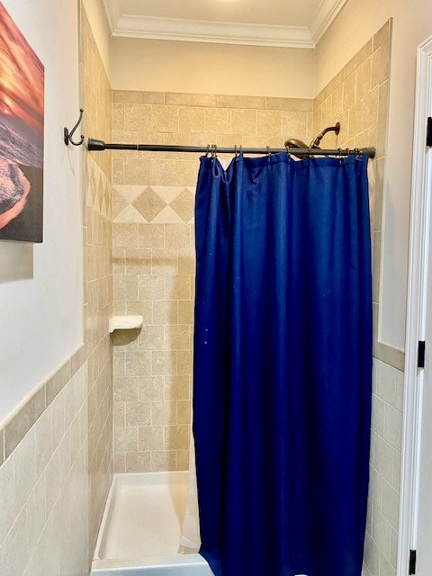 full bath with a stall shower, crown molding, and tile walls