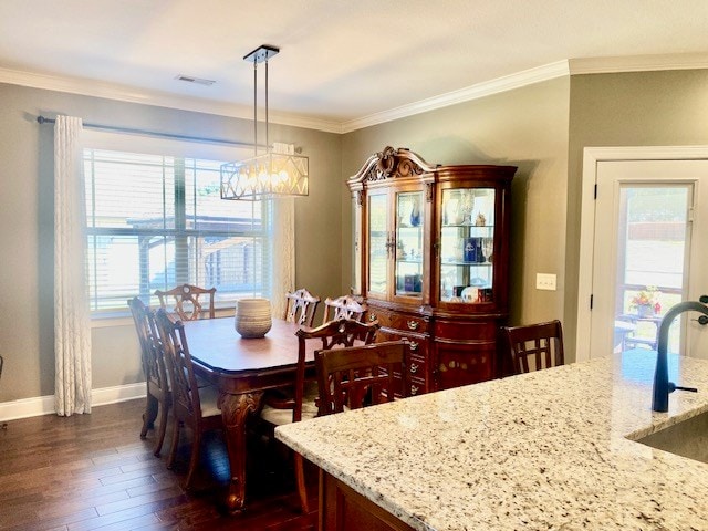 dining space featuring visible vents, baseboards, dark wood finished floors, and crown molding