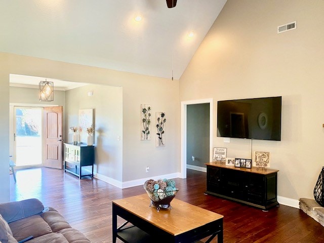 living area featuring high vaulted ceiling, baseboards, visible vents, and wood finished floors