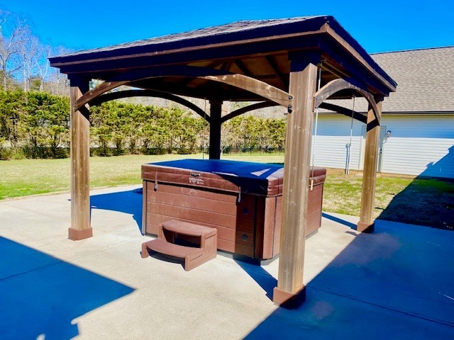 view of patio / terrace featuring a hot tub and a gazebo