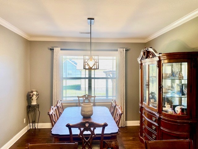 dining space featuring crown molding, baseboards, and wood finished floors