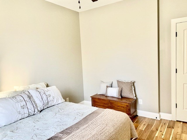 bedroom featuring a ceiling fan, light wood-type flooring, and baseboards