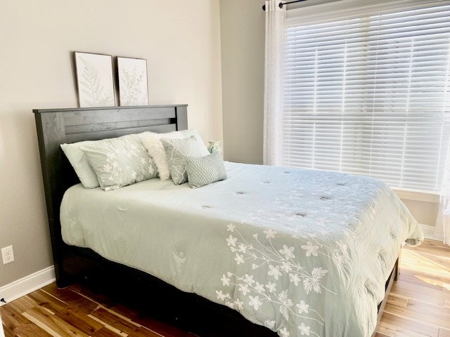 bedroom featuring wood finished floors and baseboards