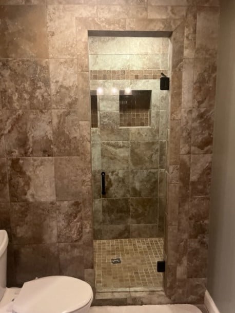 bathroom with toilet and a shower with shower door