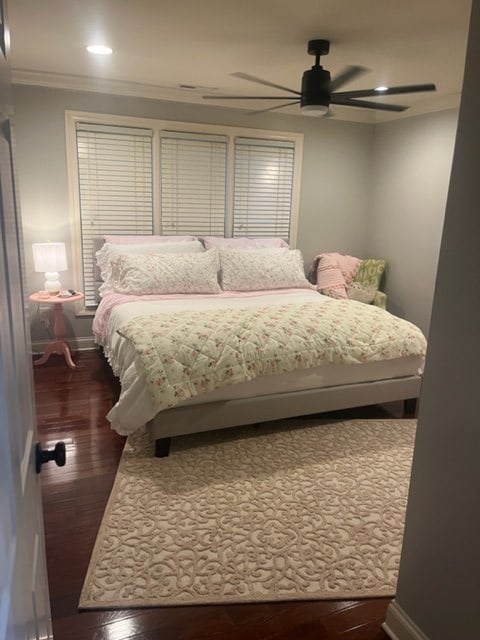 bedroom featuring crown molding, dark hardwood / wood-style floors, and ceiling fan