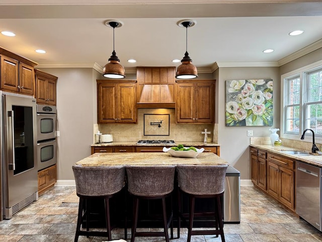 kitchen featuring light stone counters, appliances with stainless steel finishes, sink, and a kitchen island