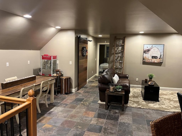 interior space featuring a barn door and lofted ceiling