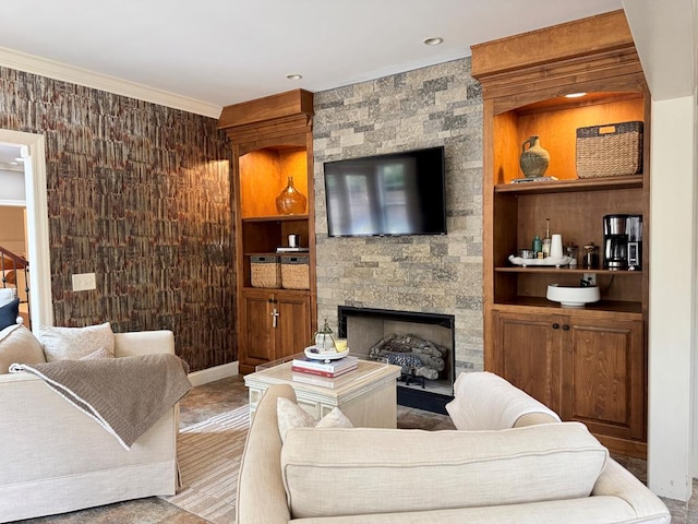 living room featuring crown molding, a large fireplace, and built in shelves