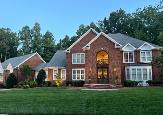 view of front facade with a front yard and french doors