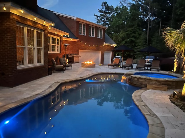 view of swimming pool featuring an in ground hot tub, an outdoor fire pit, and a patio area