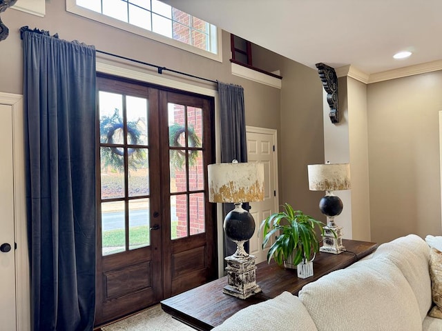 entrance foyer with crown molding and french doors