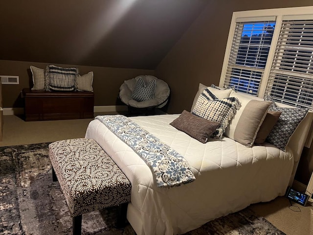 carpeted bedroom with lofted ceiling