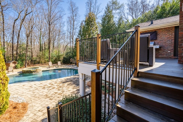 view of swimming pool featuring a deck and an in ground hot tub