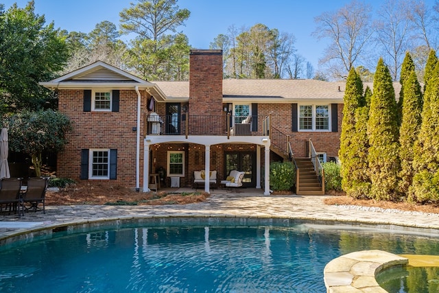 rear view of house featuring a patio and a balcony