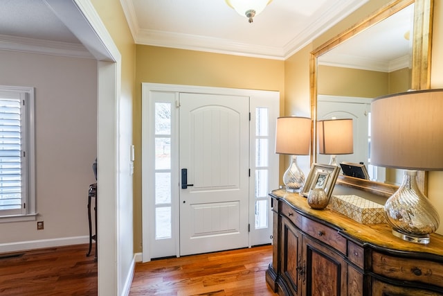 entrance foyer featuring crown molding, a wealth of natural light, and dark hardwood / wood-style floors