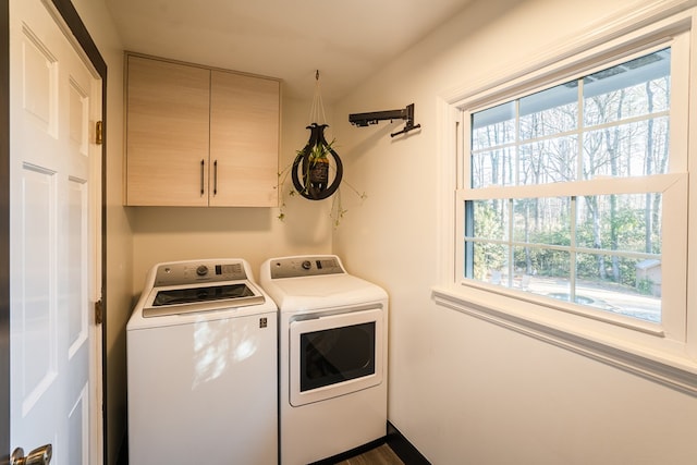 laundry room featuring washing machine and dryer and cabinets