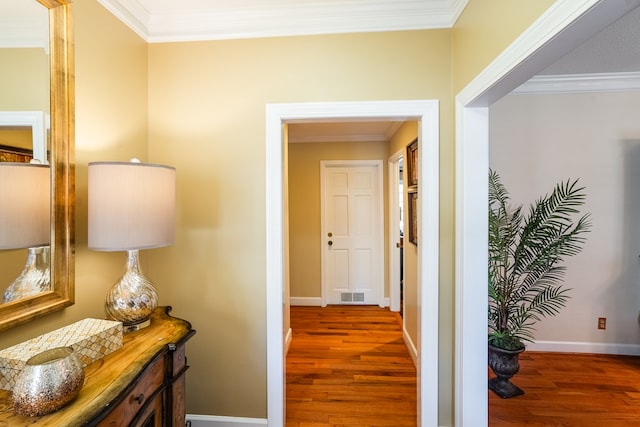 hallway with ornamental molding and dark hardwood / wood-style flooring