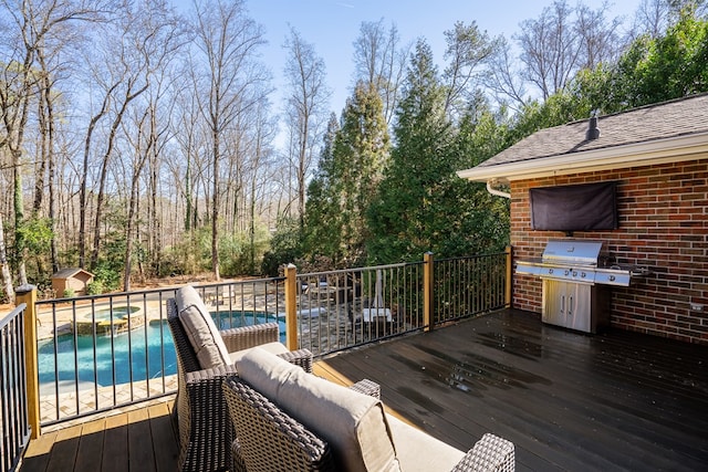 deck with a fenced in pool and grilling area