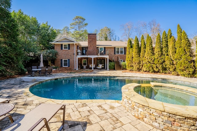 view of pool featuring an in ground hot tub and a patio area