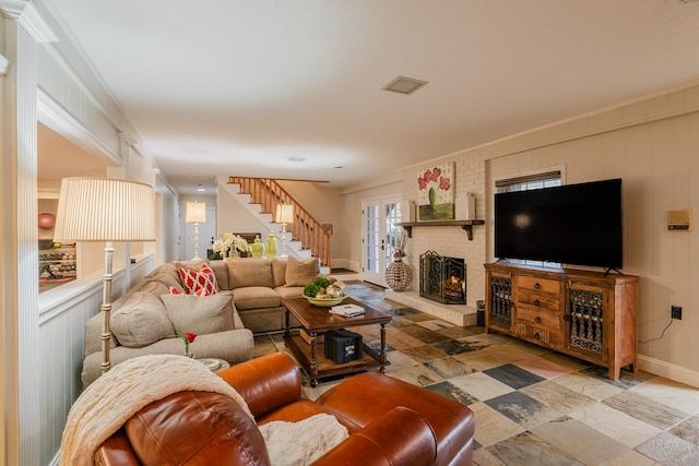 living room with crown molding and a fireplace