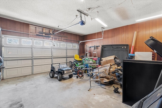 garage with a garage door opener and wood walls