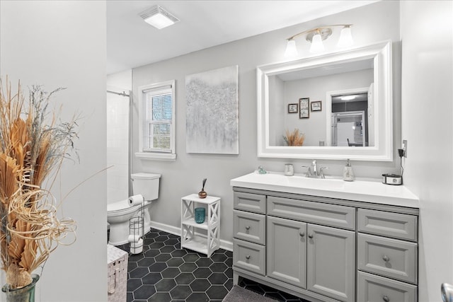 bathroom with vanity, tile patterned flooring, toilet, and walk in shower