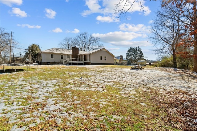 rear view of property with a trampoline